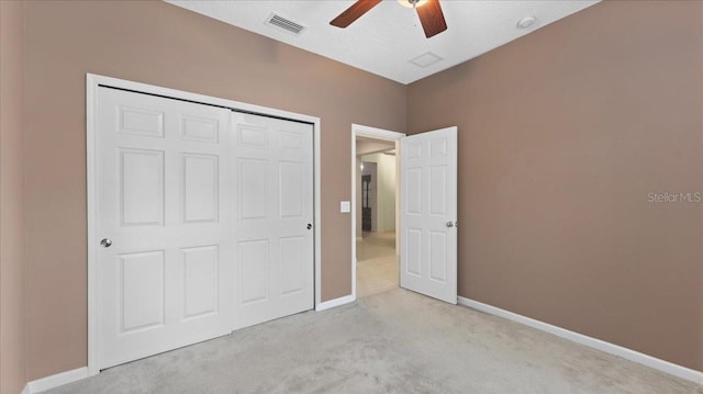 unfurnished bedroom featuring light colored carpet, ceiling fan, and a closet