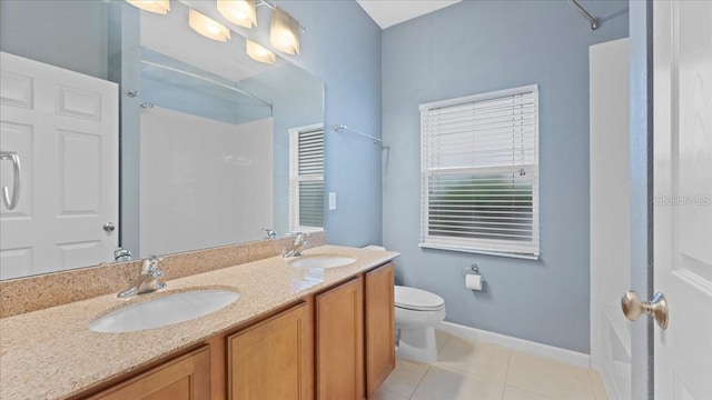 bathroom with vanity, toilet, tile patterned flooring, and a shower