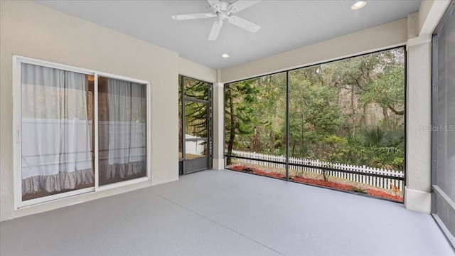 unfurnished sunroom featuring ceiling fan