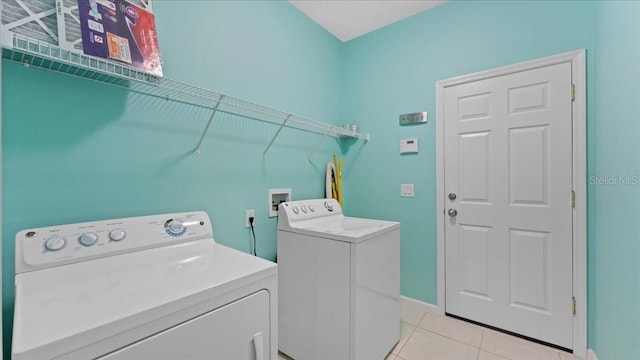 washroom with washer and dryer and light tile patterned floors