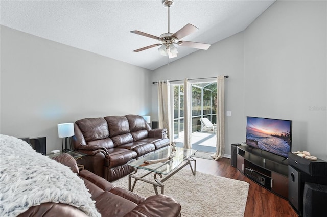 living room with a textured ceiling, ceiling fan, dark hardwood / wood-style flooring, and vaulted ceiling