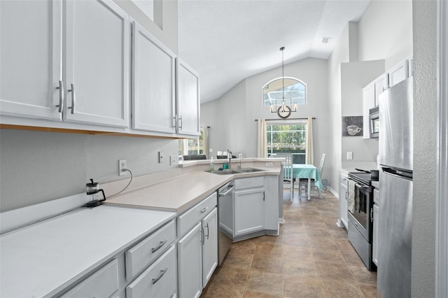 kitchen featuring sink, lofted ceiling, decorative light fixtures, white cabinets, and appliances with stainless steel finishes