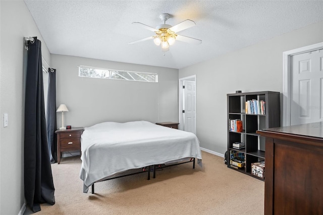 carpeted bedroom with ceiling fan and a textured ceiling