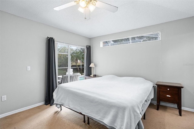 bedroom featuring ceiling fan, light carpet, and a textured ceiling