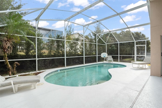 view of pool featuring glass enclosure and a patio