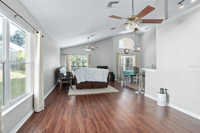 interior space featuring ceiling fan with notable chandelier, dark wood-type flooring, and vaulted ceiling