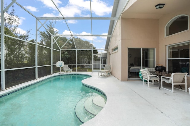 view of pool featuring glass enclosure and a patio area