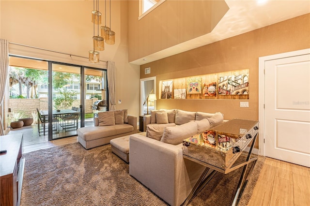 living room with hardwood / wood-style floors and a towering ceiling