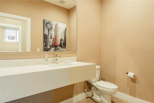 bathroom with hardwood / wood-style flooring, sink, and toilet