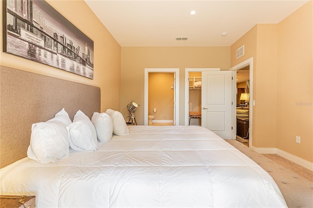 bedroom featuring carpet flooring, a walk in closet, ensuite bath, and a closet