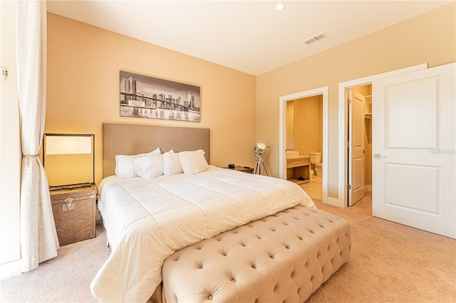 carpeted bedroom with a spacious closet and ensuite bath