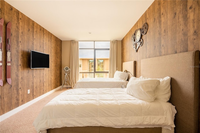 carpeted bedroom featuring wood walls