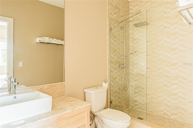 bathroom featuring tiled shower, vanity, and toilet