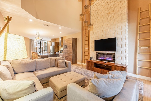 living room featuring built in shelves, recessed lighting, a high ceiling, visible vents, and baseboards