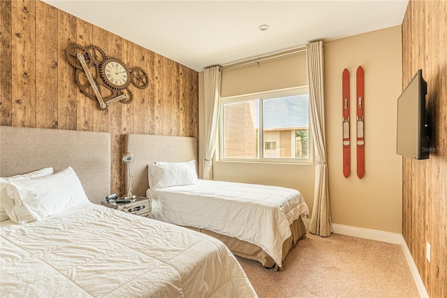 bedroom featuring wooden walls, baseboards, and carpet flooring