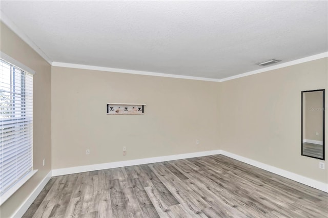 unfurnished room with crown molding, a textured ceiling, and light hardwood / wood-style floors