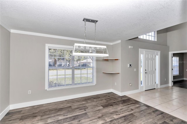 entryway featuring hardwood / wood-style flooring, a textured ceiling, and ornamental molding