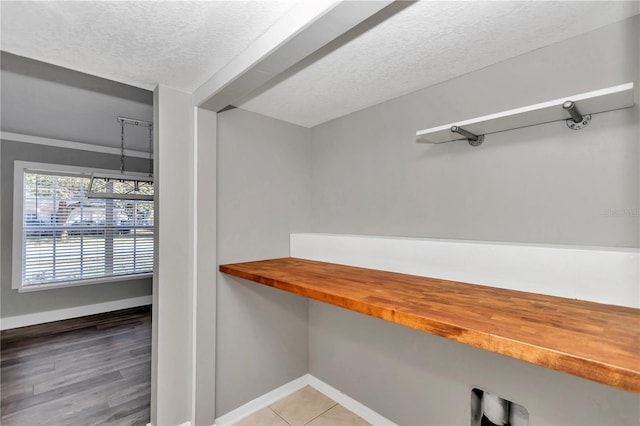 interior space with a textured ceiling and tile patterned flooring