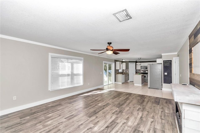 unfurnished living room with light wood-type flooring, ceiling fan, ornamental molding, and a textured ceiling