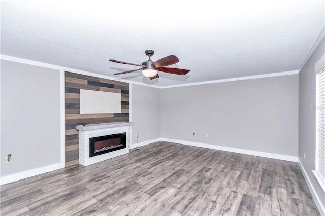 unfurnished living room with ceiling fan, hardwood / wood-style floors, ornamental molding, and a textured ceiling