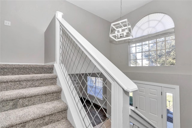 staircase with a chandelier