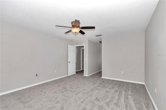 carpeted spare room with ceiling fan and a textured ceiling