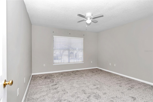 carpeted spare room with a textured ceiling and ceiling fan