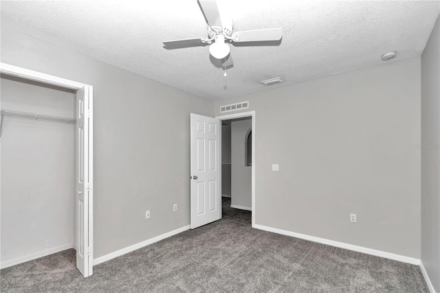 unfurnished bedroom featuring a textured ceiling, ceiling fan, a closet, and carpet floors