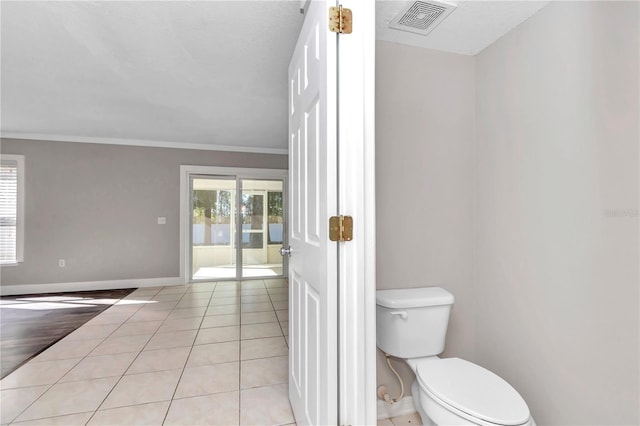 bathroom featuring toilet, tile patterned flooring, and ornamental molding