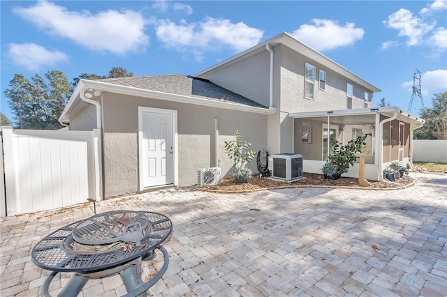 rear view of property featuring ac unit, cooling unit, a sunroom, and a patio