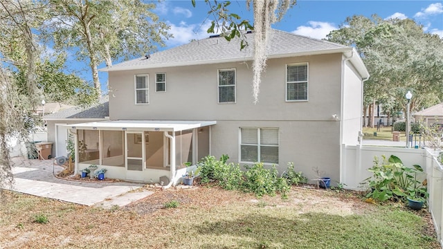 back of property with a yard and a sunroom