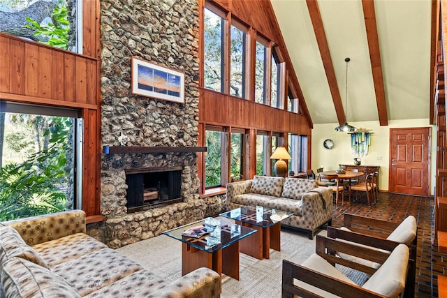 living room with high vaulted ceiling, beamed ceiling, plenty of natural light, wooden walls, and a fireplace