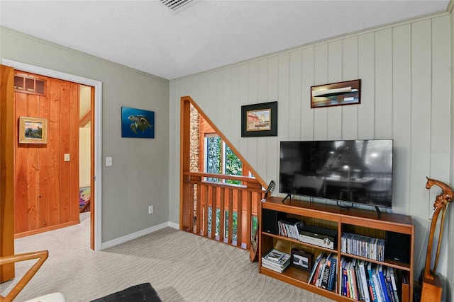 carpeted living room with wood walls