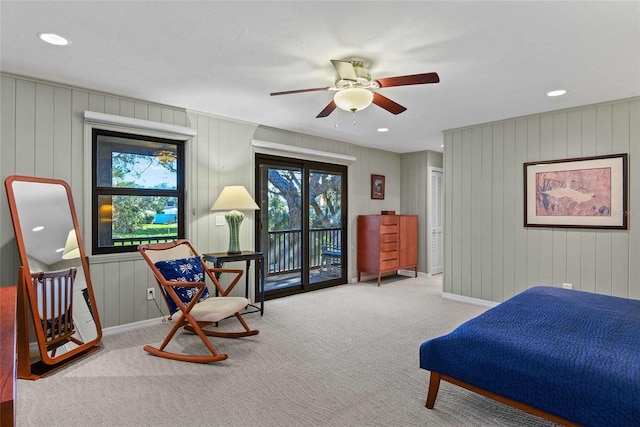 bedroom featuring access to outside, ceiling fan, carpet floors, and wood walls