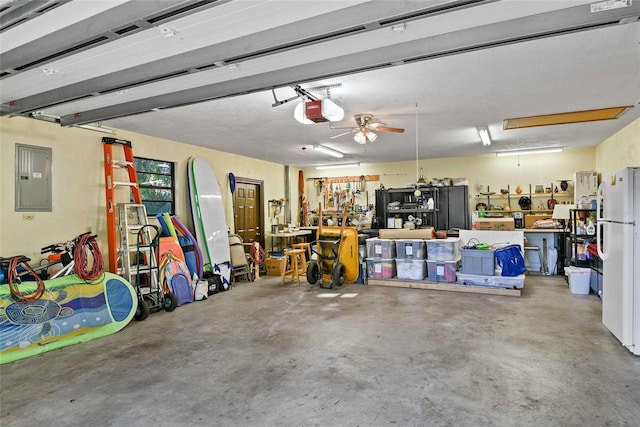 garage with electric panel, white fridge, a garage door opener, and ceiling fan