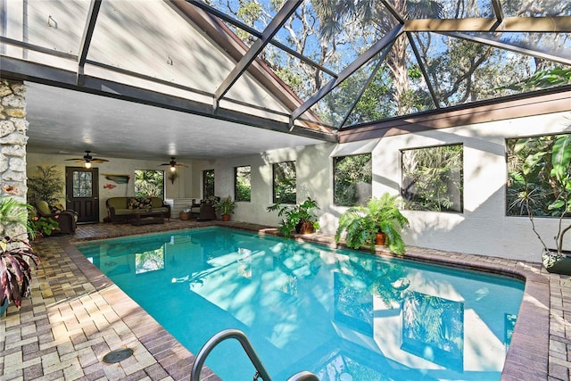 view of swimming pool with ceiling fan, a patio area, a lanai, and an outdoor living space