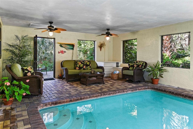 view of swimming pool with ceiling fan and a jacuzzi