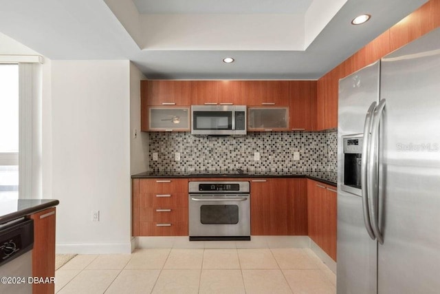 kitchen with backsplash, light tile patterned floors, and stainless steel appliances