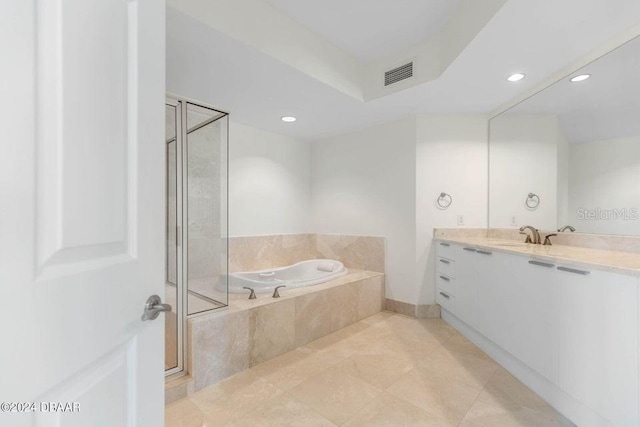 bathroom featuring vanity, tile patterned floors, and tiled tub