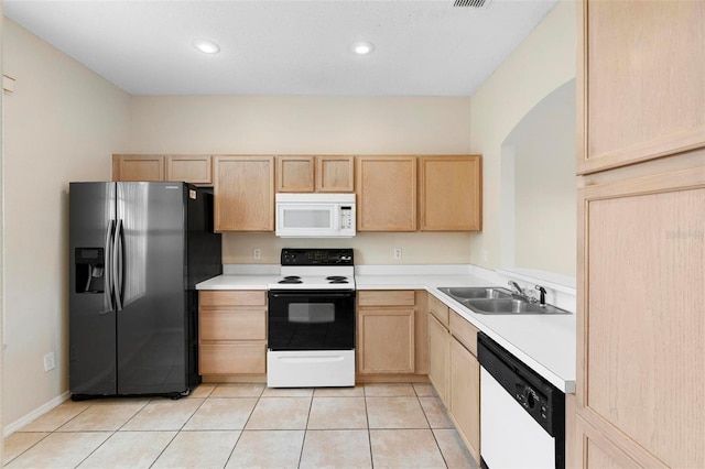 kitchen featuring sink, light tile patterned floors, light brown cabinetry, and white appliances