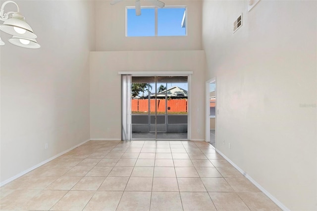 tiled empty room with a towering ceiling