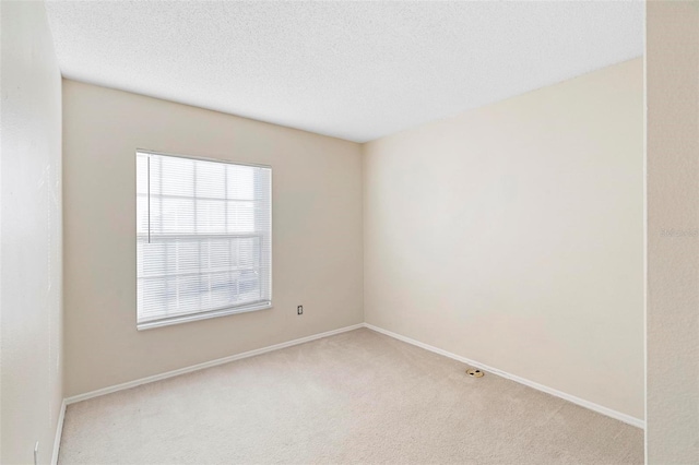 carpeted spare room with a textured ceiling