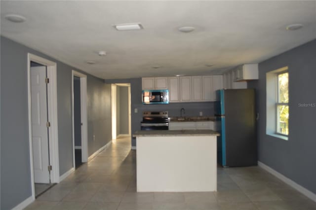 kitchen with sink, light tile patterned flooring, stainless steel appliances, and a center island