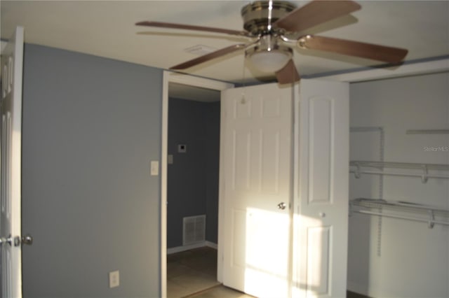 unfurnished bedroom featuring ceiling fan, tile patterned floors, and a closet