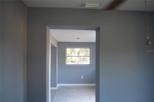 hall with light tile patterned floors