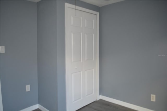 unfurnished bedroom featuring a closet and dark hardwood / wood-style floors