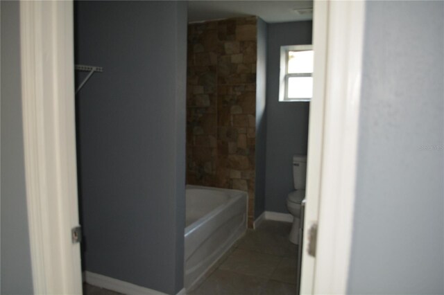 bathroom featuring toilet, tile patterned flooring, and bathing tub / shower combination