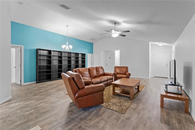 living room featuring hardwood / wood-style floors, ceiling fan with notable chandelier, and vaulted ceiling