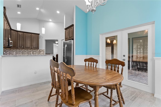 dining room with high vaulted ceiling and french doors