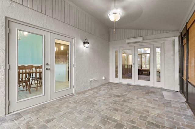 unfurnished sunroom with lofted ceiling, french doors, ceiling fan, and a wall mounted air conditioner